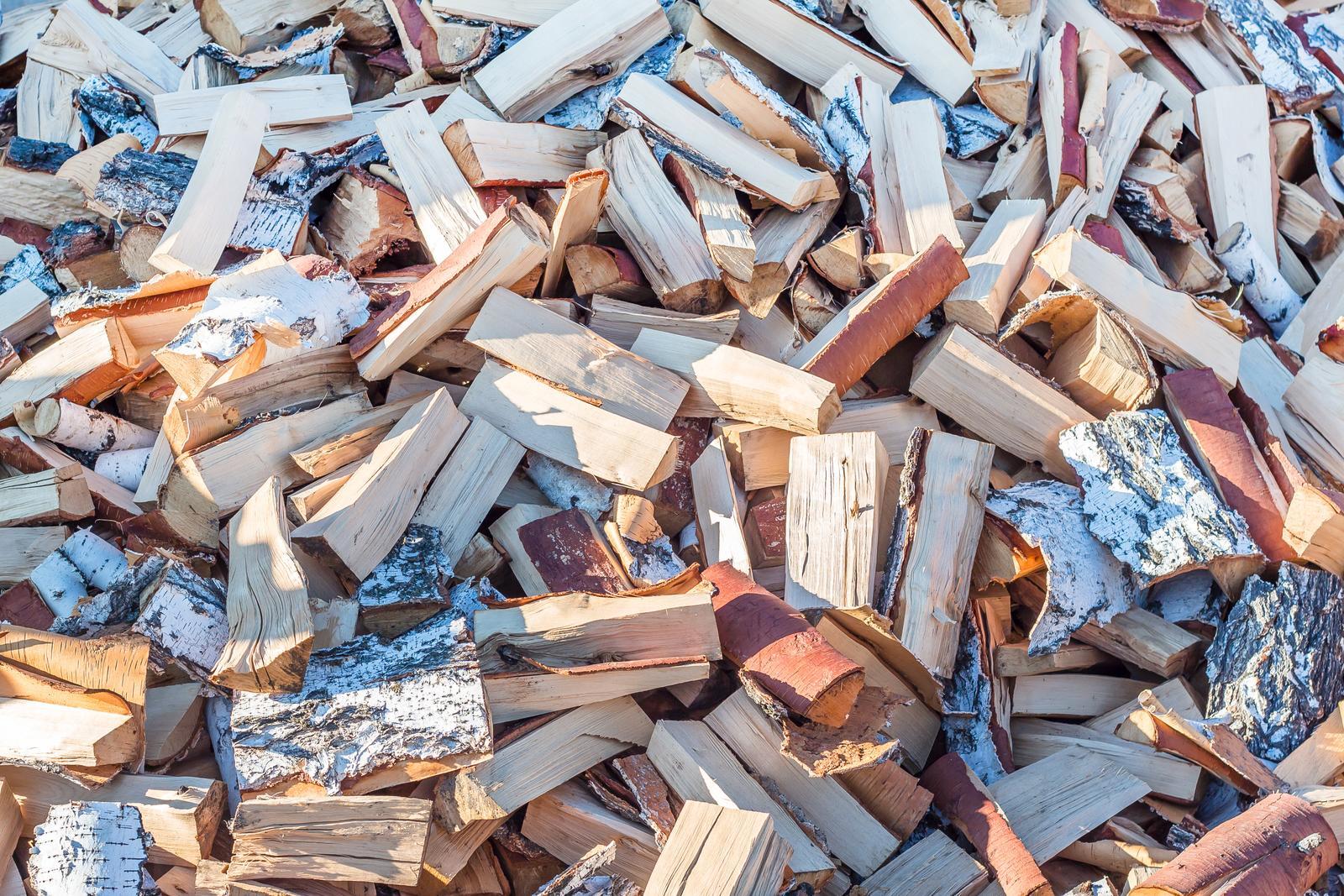 A pile of chopped wood is sitting on the ground.