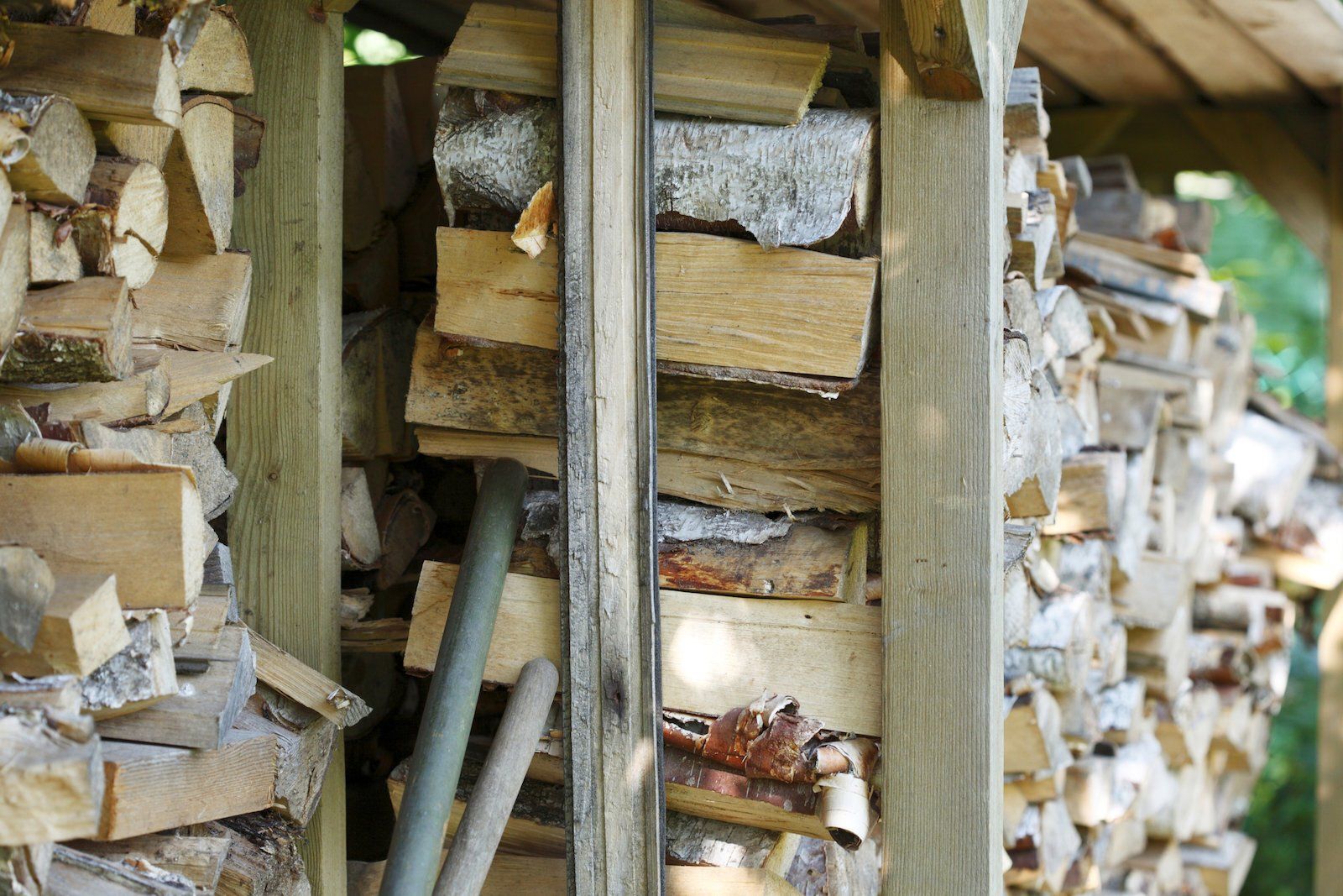 A pile of logs stacked on top of each other in a wooden shed.