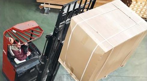 operatore a bordo di un muletto si occupa del trasporto di uno scatolone