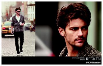 A man is walking down a street next to a picture of another man.
