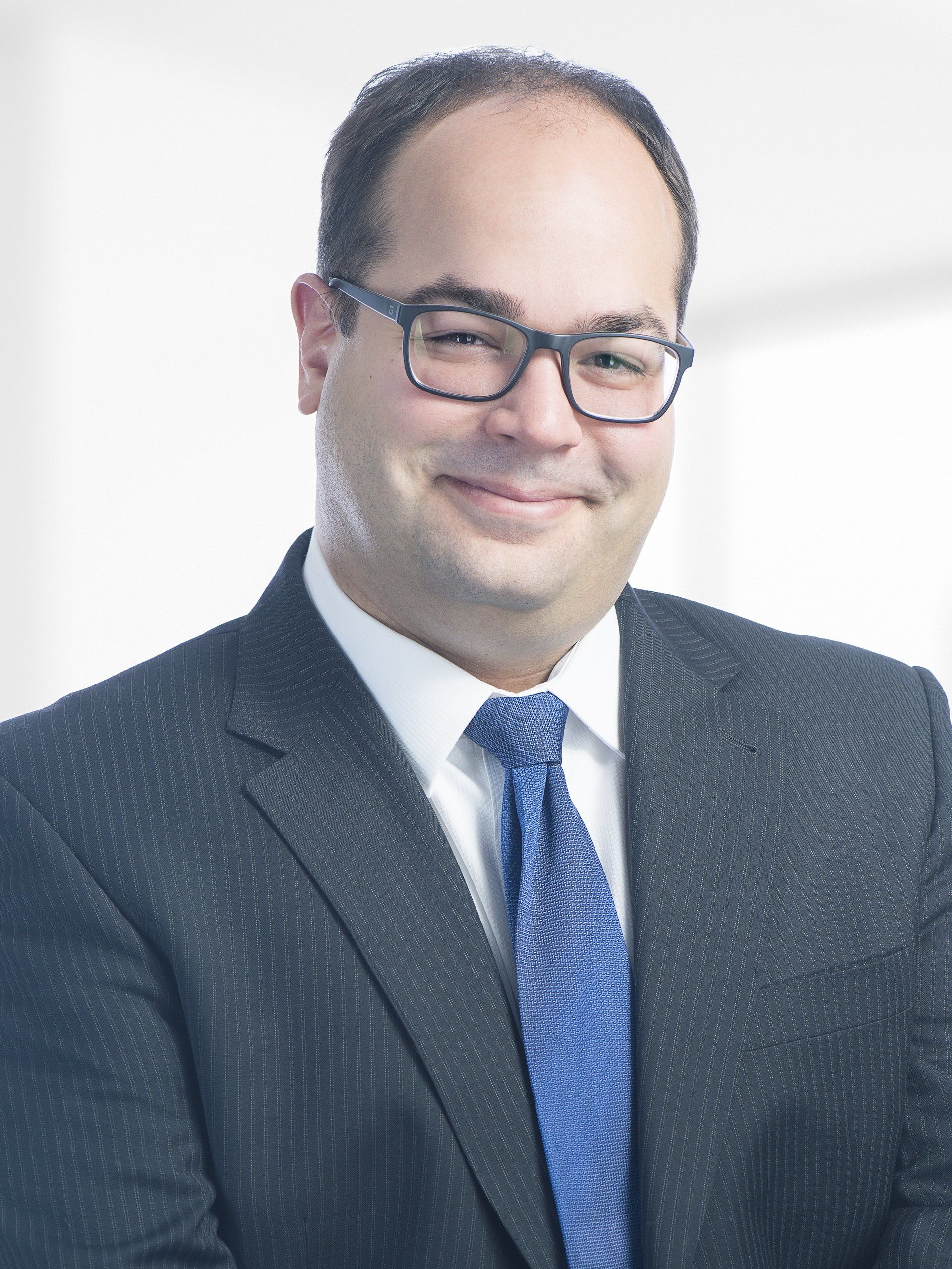 A man in a suit and tie is smiling for the camera.