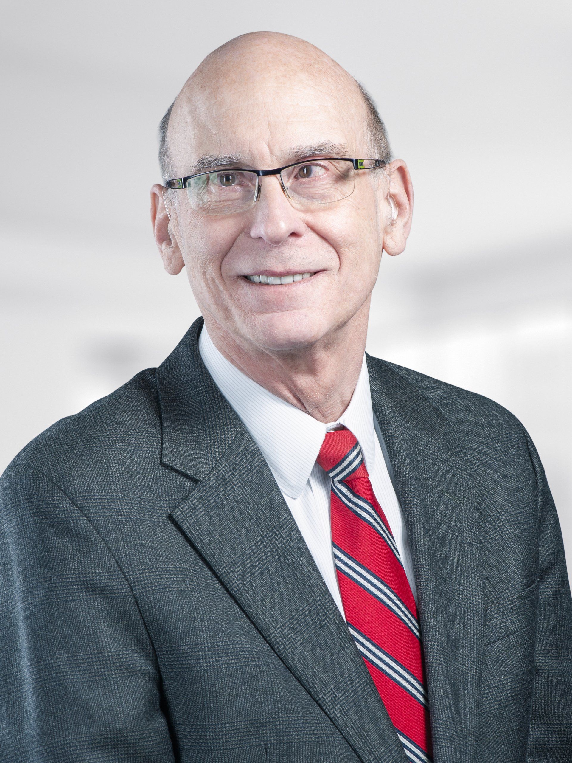 A man in a suit and tie is smiling for the camera.