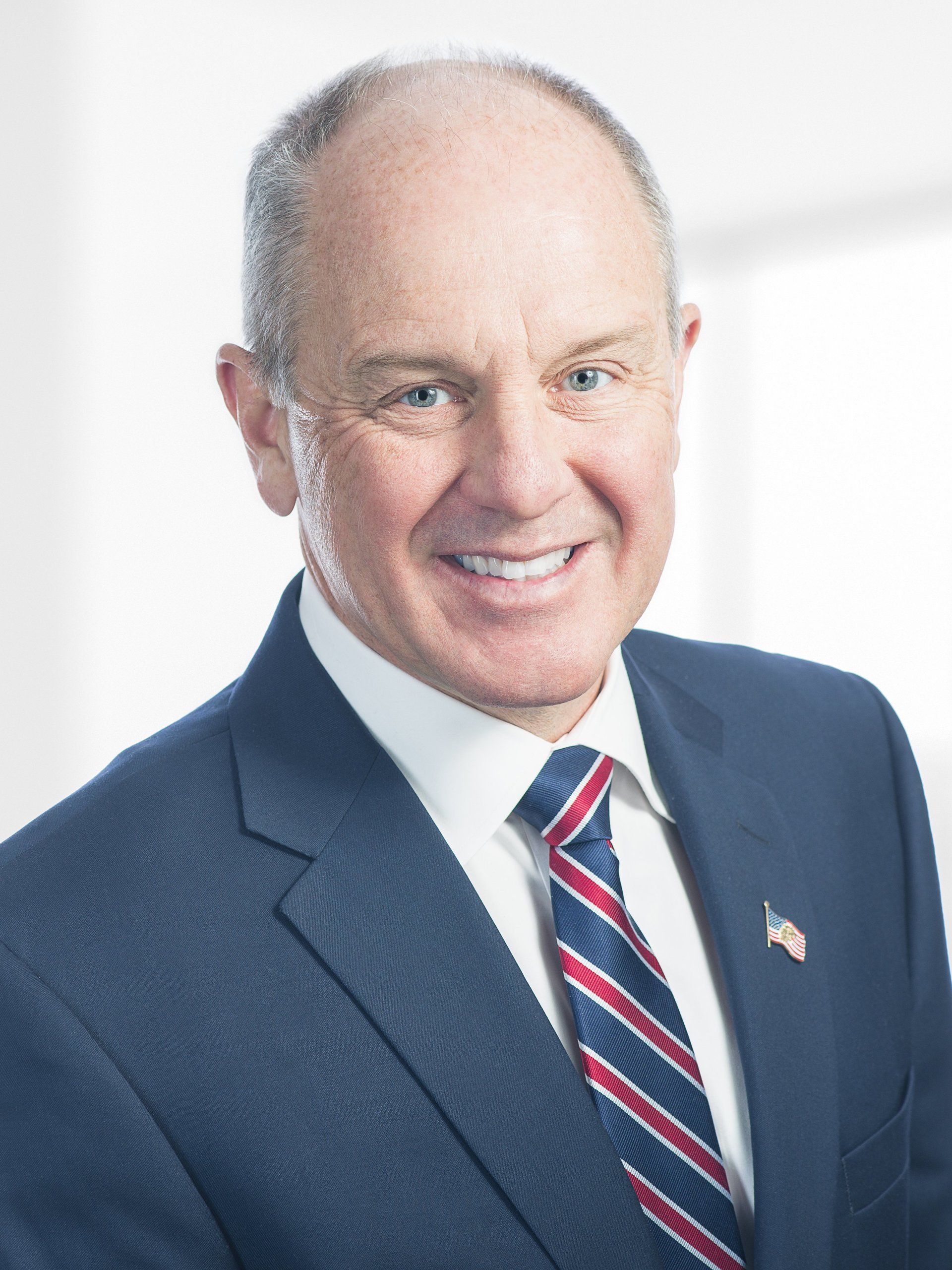 A man in a suit and tie is smiling for the camera.