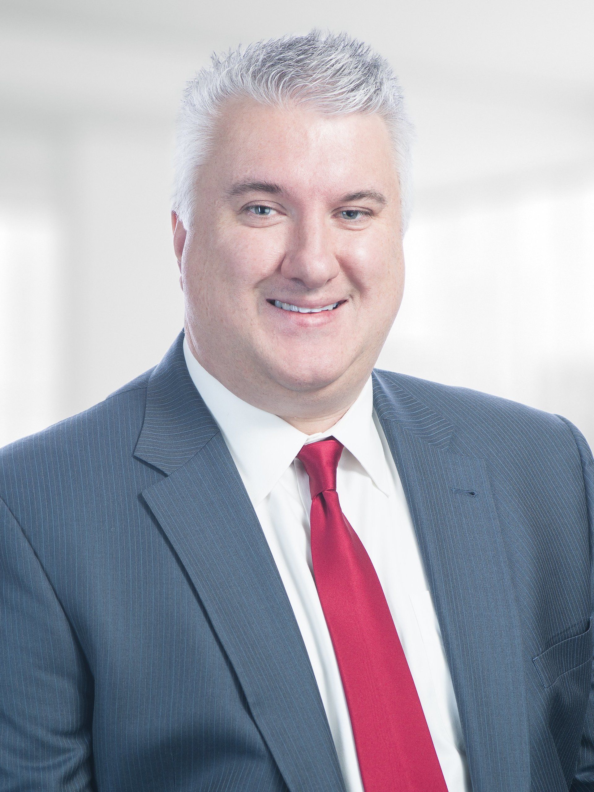 A man in a suit and tie is smiling for the camera.