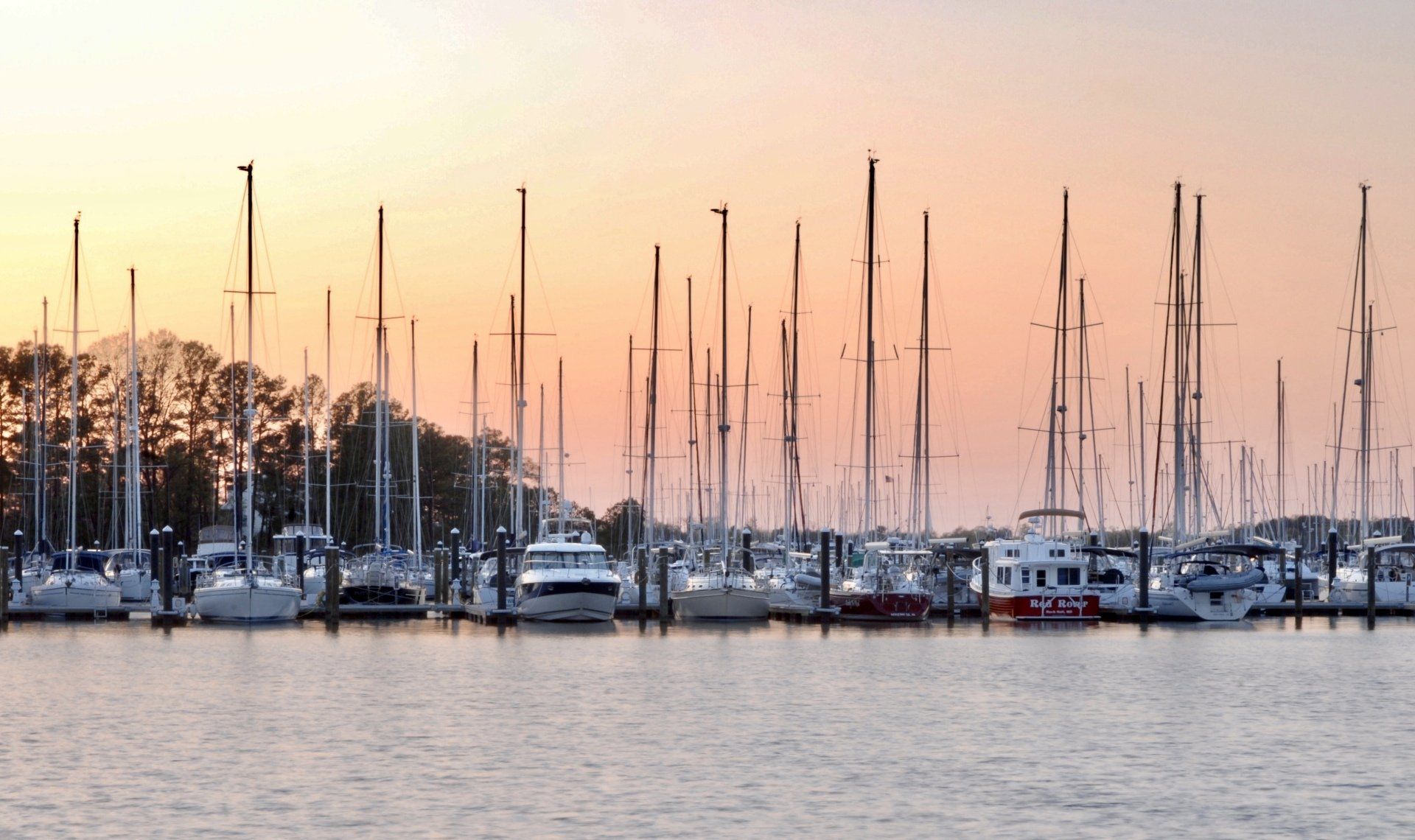 Sailboats, marina and dock during summer sunset