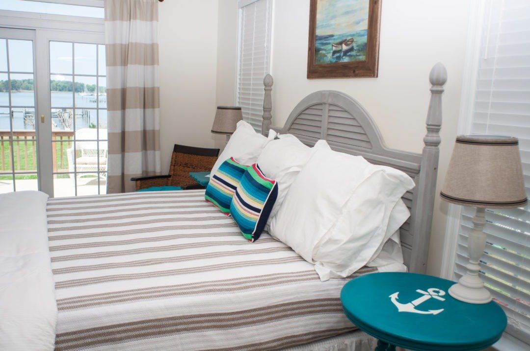 Bedroom, bed and balcony with stripped bedding and white pillows