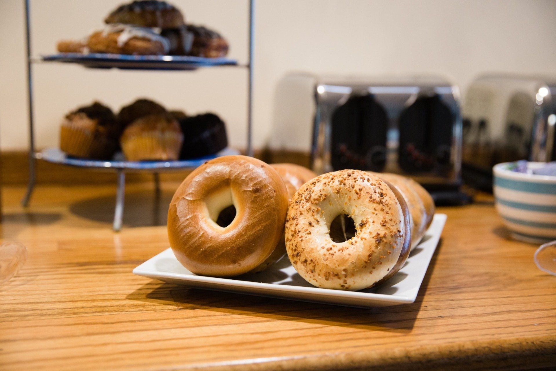 Bagels and breakfast pastries on a wooden counter