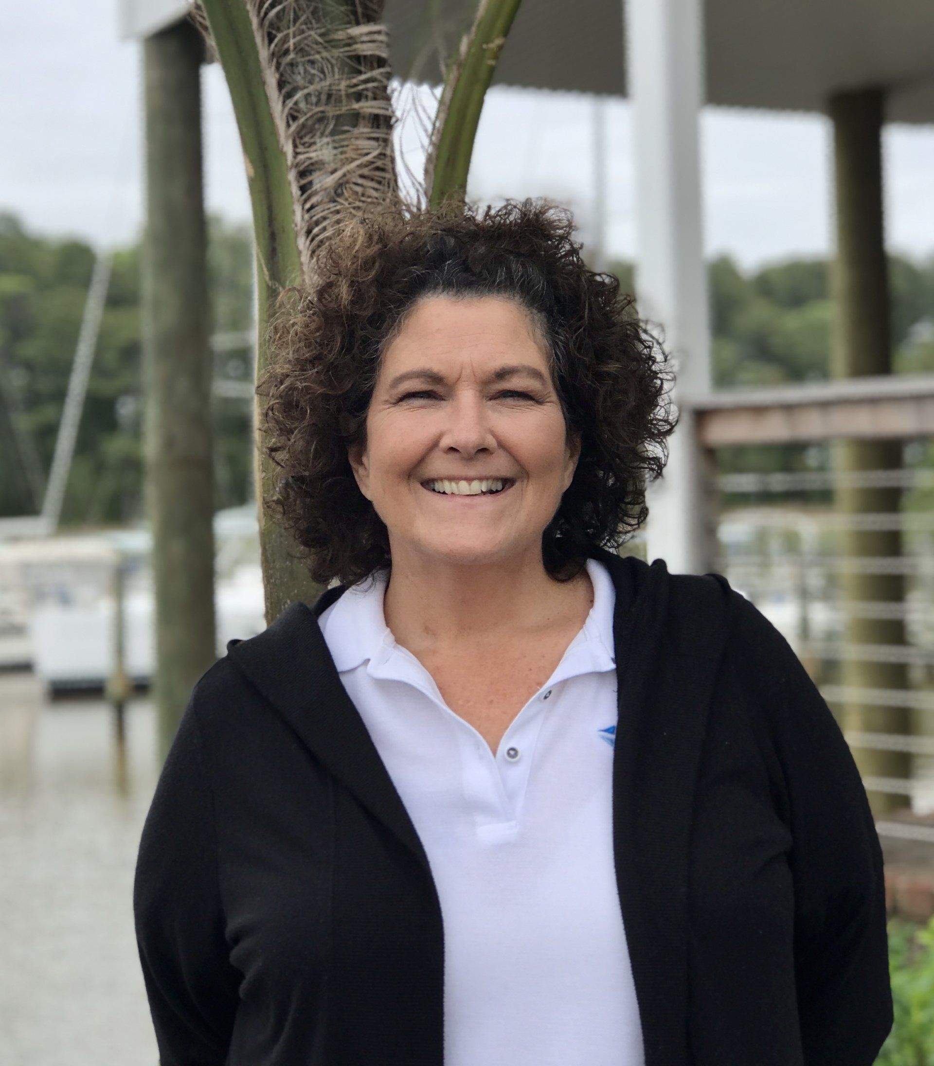 Employee face posing outside with boats in the background