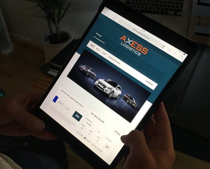 A person is holding a tablet with a tire webshop on the screen