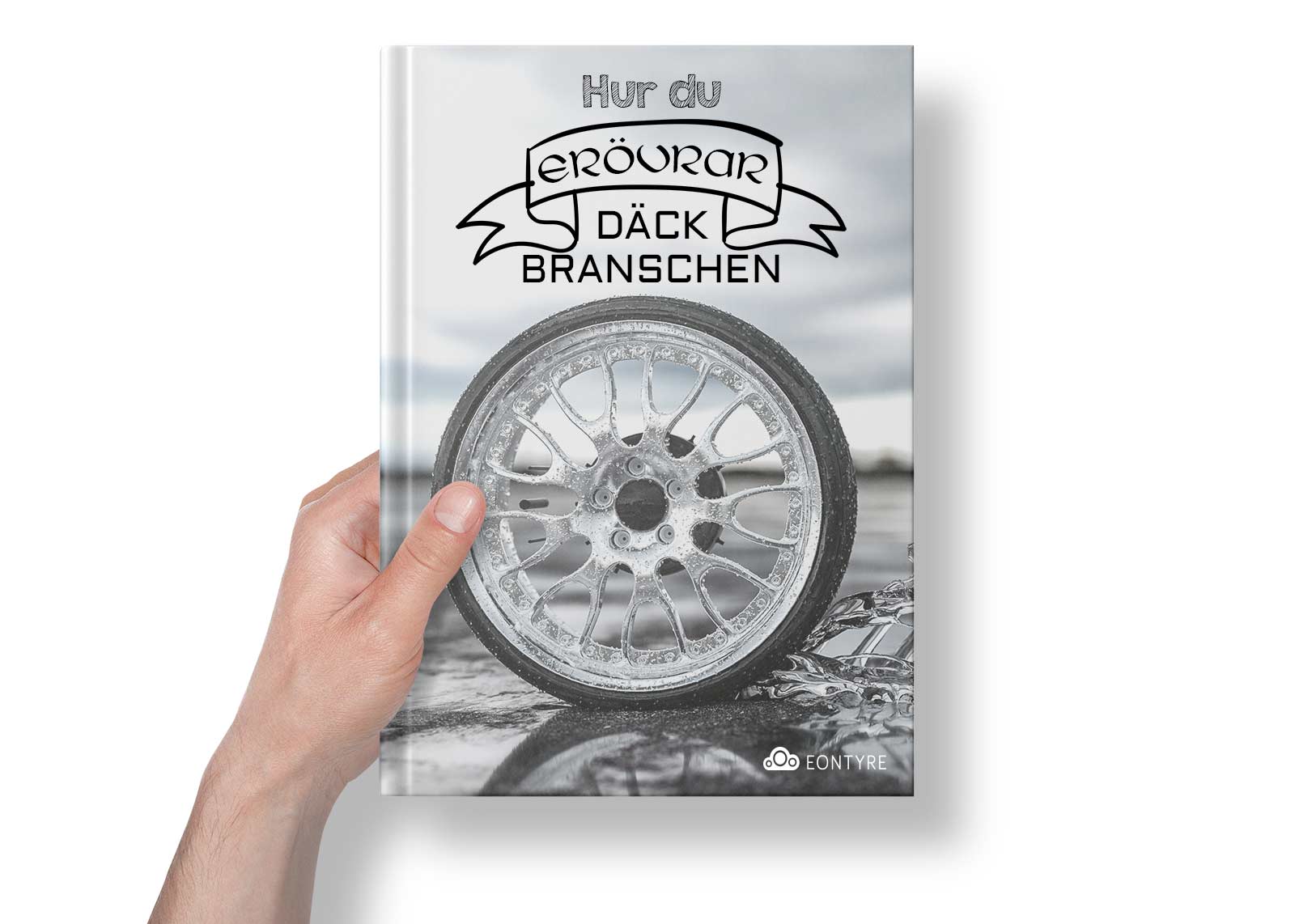 A hand is holding a book with a picture of a wheel on the cover.