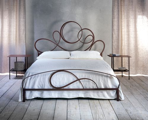 Letto matrimoniale in ferro con decori sulla testata