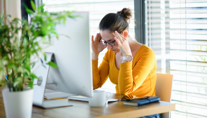 Woman working from her home office with a frustrated expression.