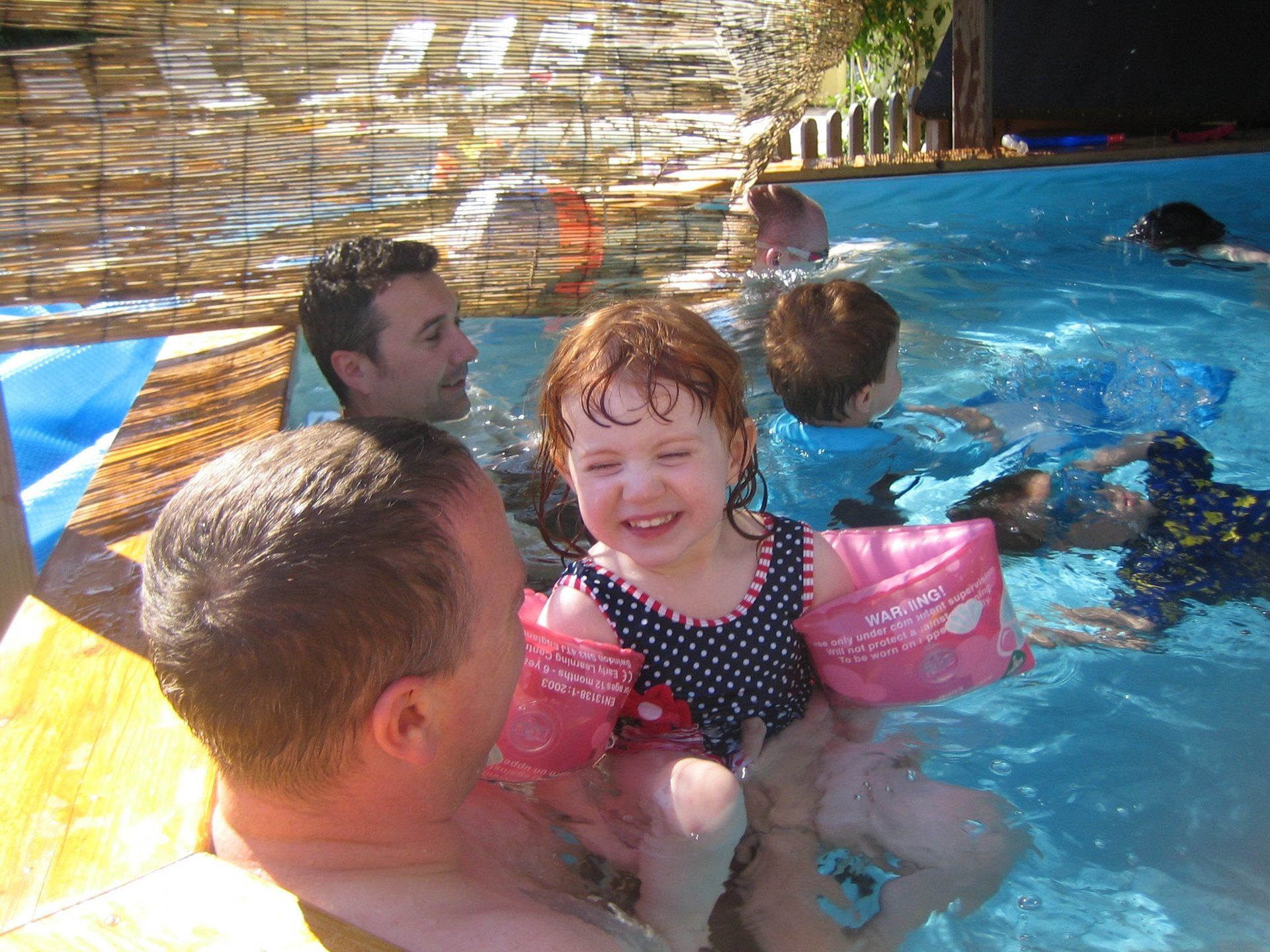 families playing in a toddler pool in France