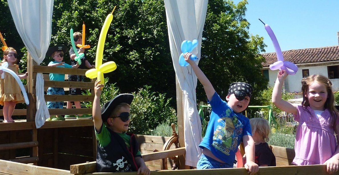 enfants jouant aux pirates sur un bateau pirate en bois dans un jardin