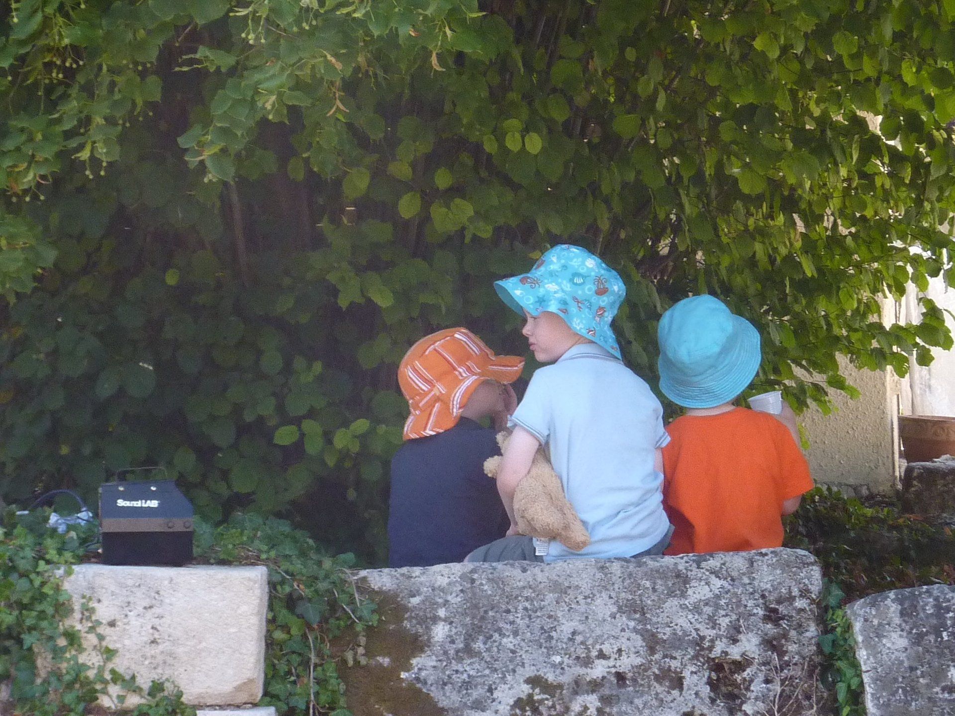 three young children sat on a wall at La Grange du Moulin