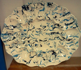 A white plate with blue and black swirls on it
