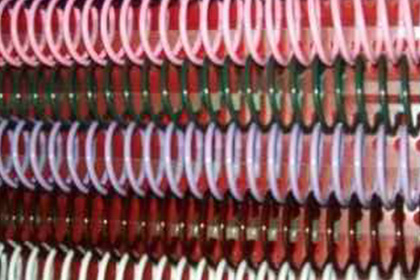 Hileras de anillos circulares rojos y blancos apilados en un denso patrón abstracto.