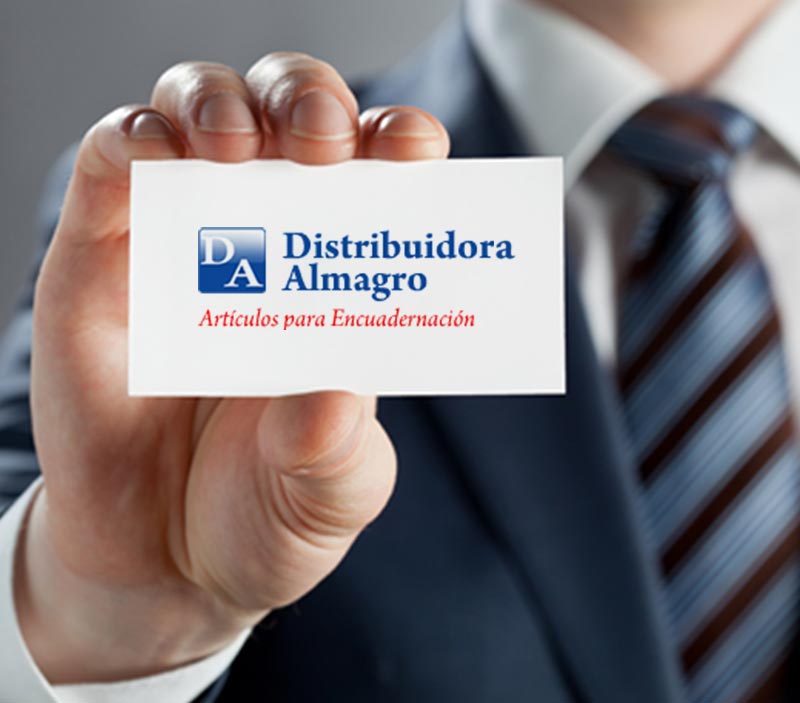 Mano sosteniendo una tarjeta de presentación con la inscripción “Distribuidora Almagro” y un traje borroso al fondo.