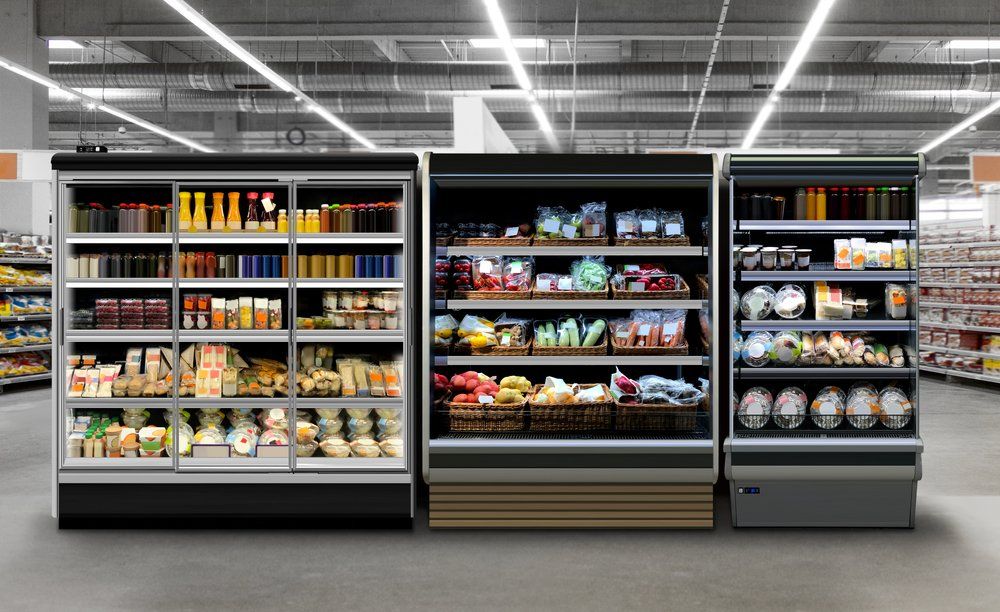 A row of refrigerators in a supermarket filled with lots of food.