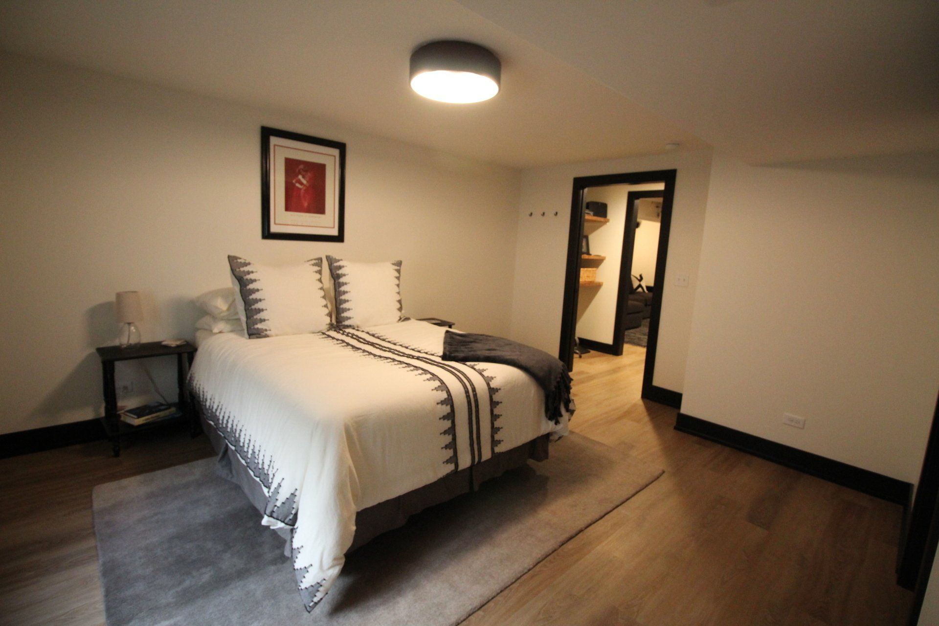 A bedroom with a bed , nightstand , and rug.