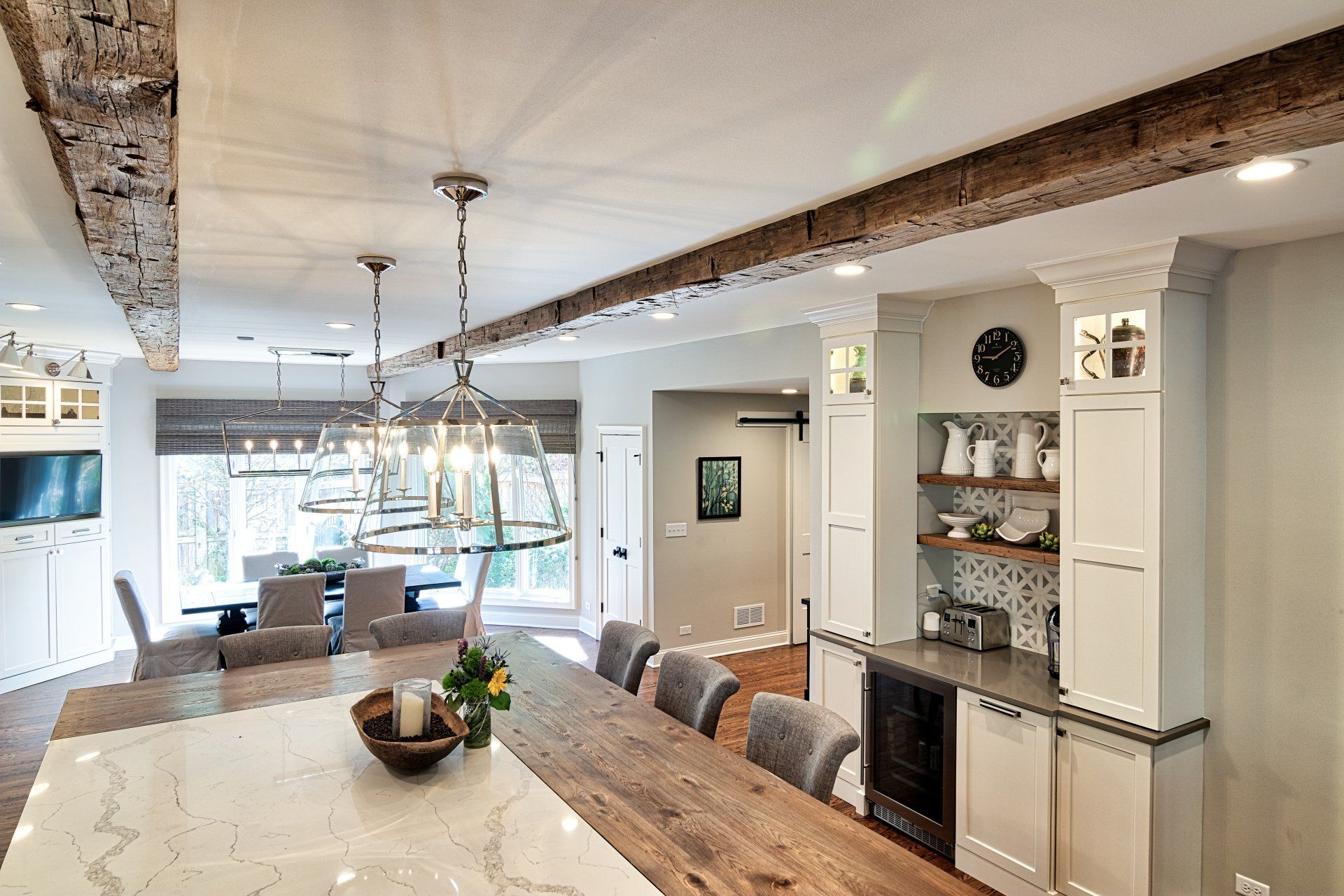 There is a large wooden table in the middle of the kitchen.