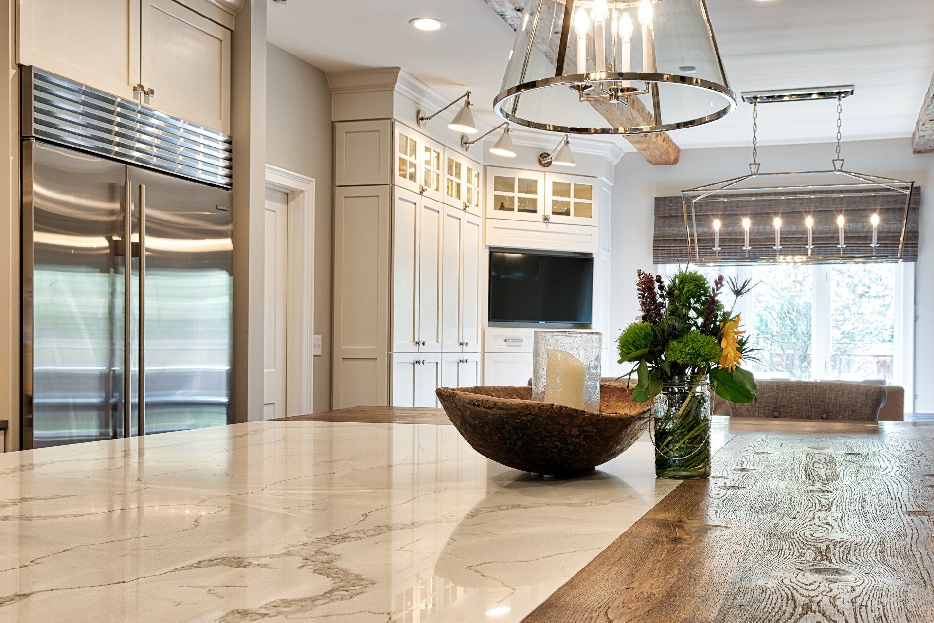 There is a bowl of flowers on the counter in the kitchen.