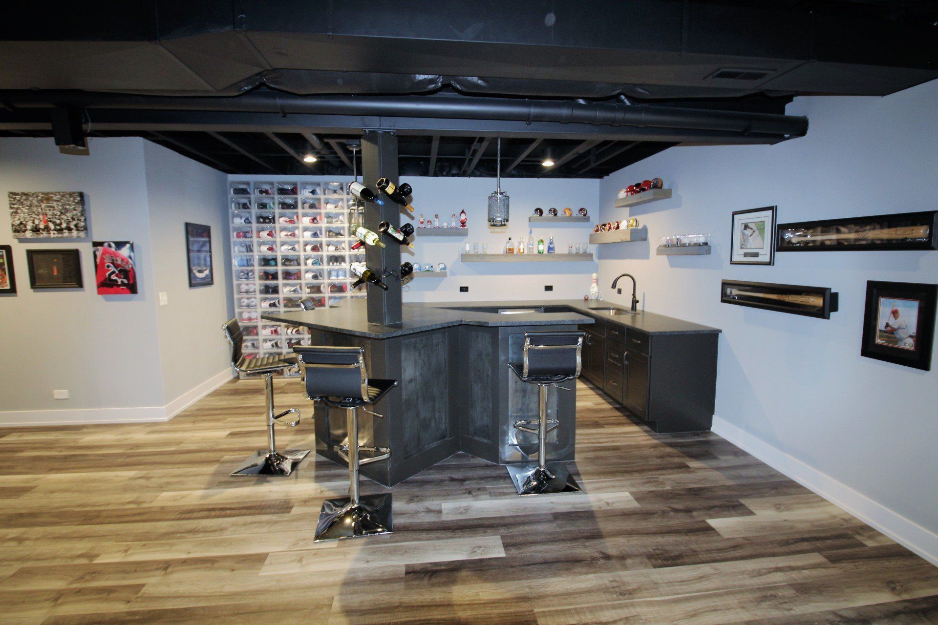 A basement with a bar and stools and a wine cellar