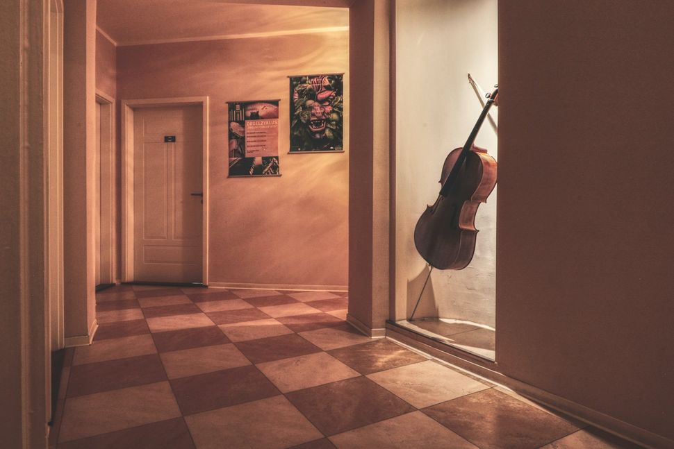 Künstlerischer Flur mit Cello und Postern – OPERA Hostel Atmosphäre pur