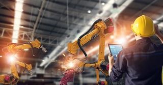 Industrial electrical repair — Engineer using tablet to control robot arms in Chino Hills, CA Industrial electrical repair — Engineer using tablet to control robot arms in Chino Hills, CA