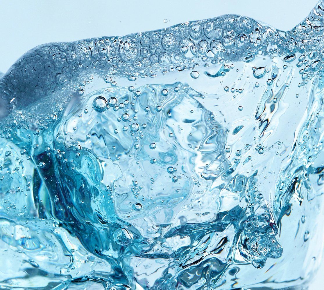 Close-up of clear blue water with bubbles, possibly ice, creating a textured surface.