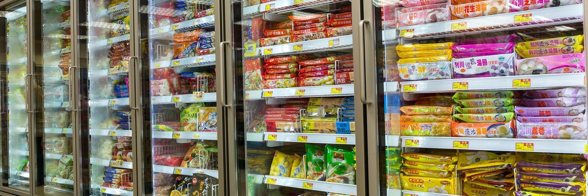 Freezer cases in a grocery store, stocked with frozen food.