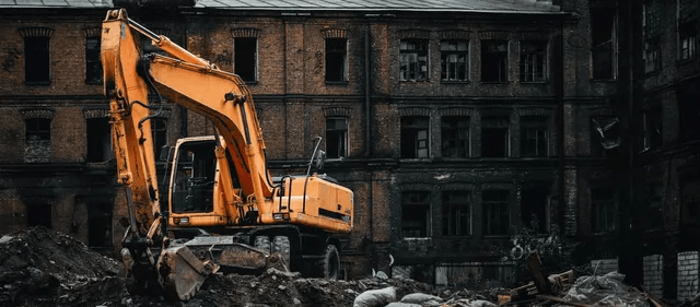 Yellow Excavator Demolishing a Brick Building, Rubble on The Ground — Walsh Demolition Pty Ltd in Grafton, NSW