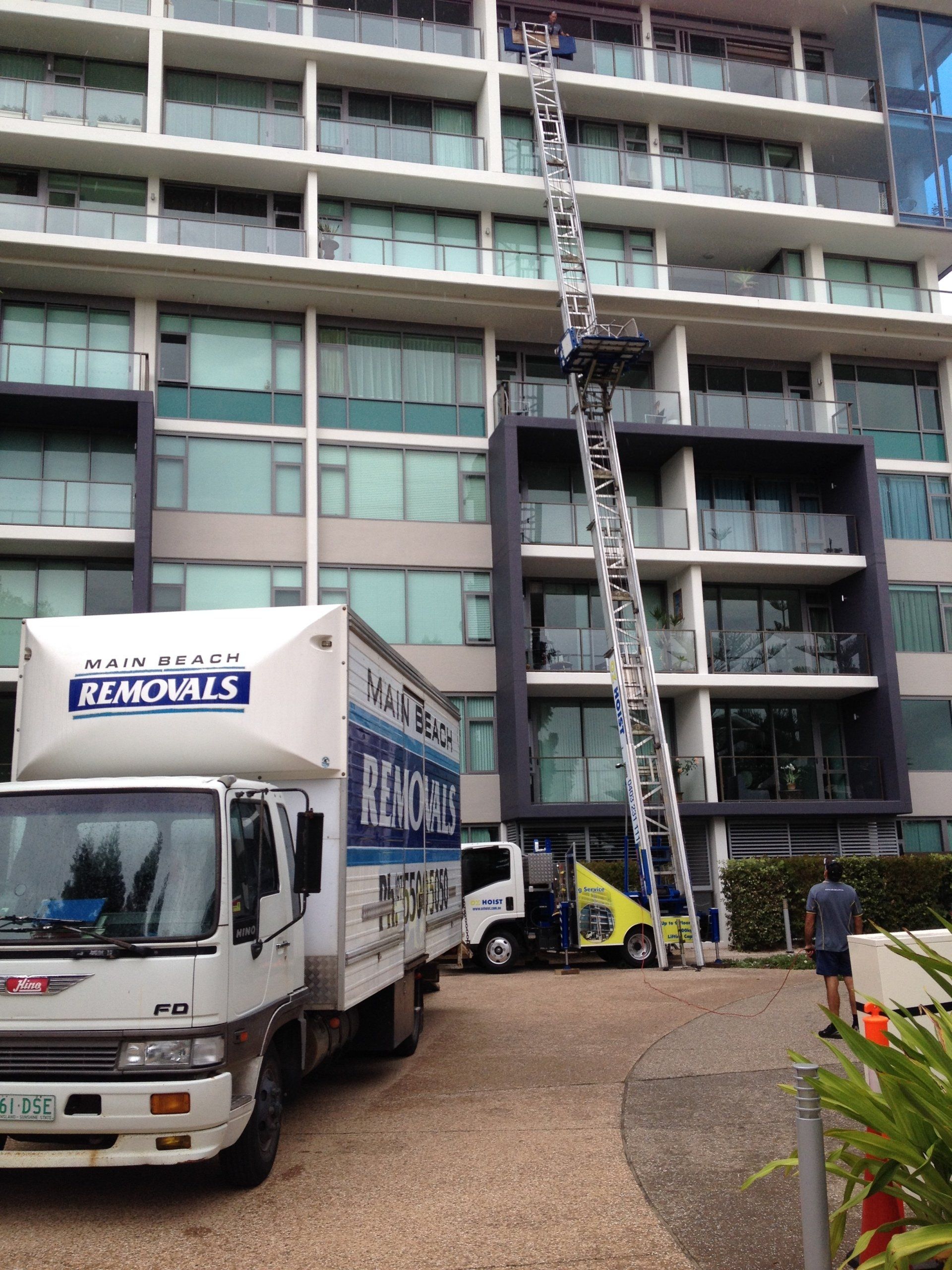 A removals truck is parked in front of a building