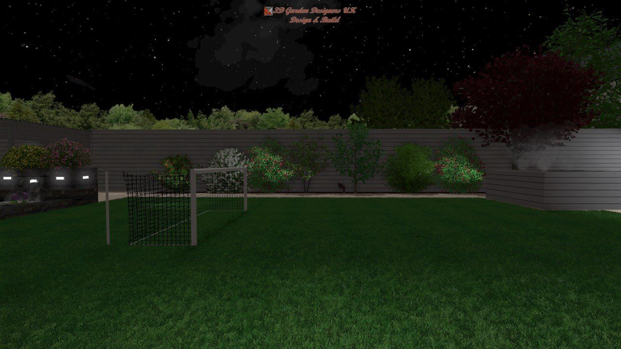 A nighttime view of a grassy backyard with a soccer goal, trees, and a wooden fence.