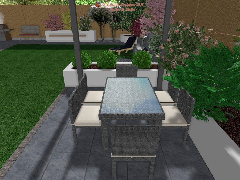 Patio with table and chairs, surrounded by greenery and garden features.