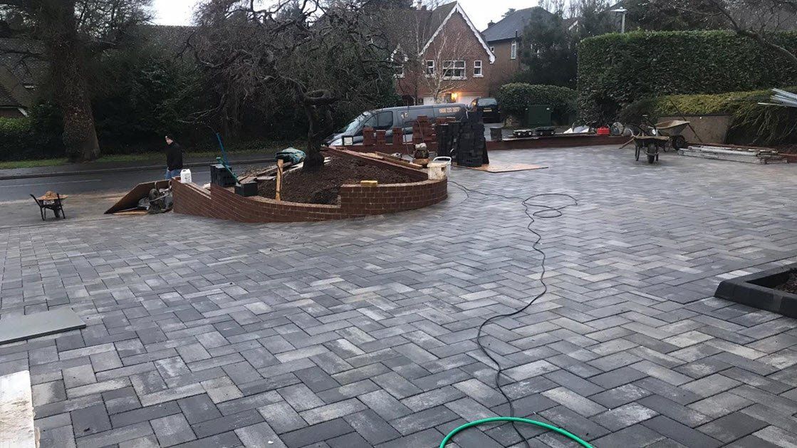 Brick structure under construction on brick paved driveway.