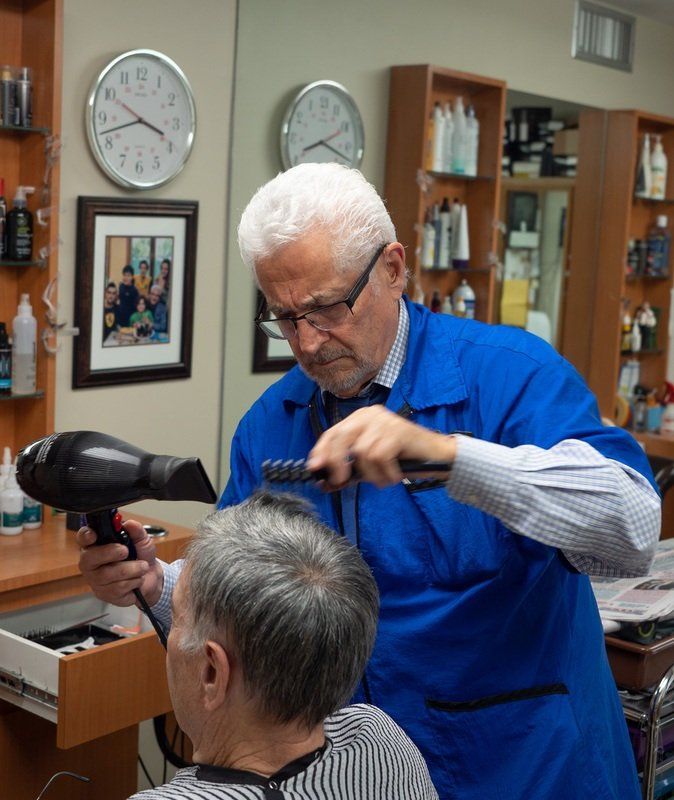 man blow drying another man's hair
