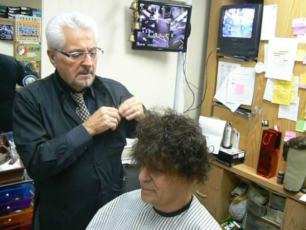 Mr. Carmine getting ready to cut man's hair