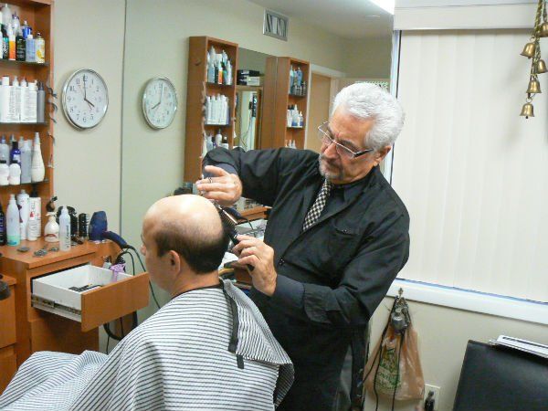 Mr. Carmine trimming man's hair