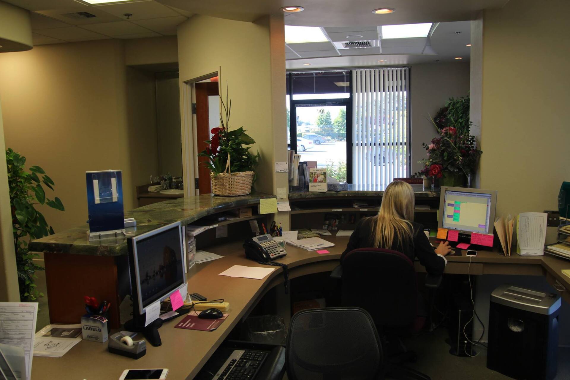A woman is sitting at a desk in front of a computer.