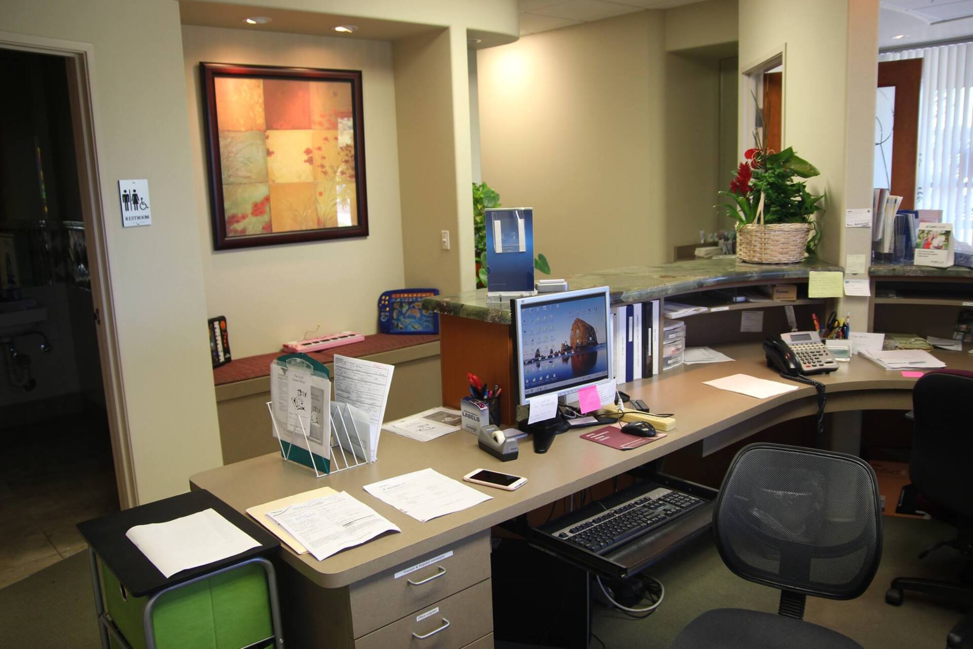A desk with a computer and a chair in an office