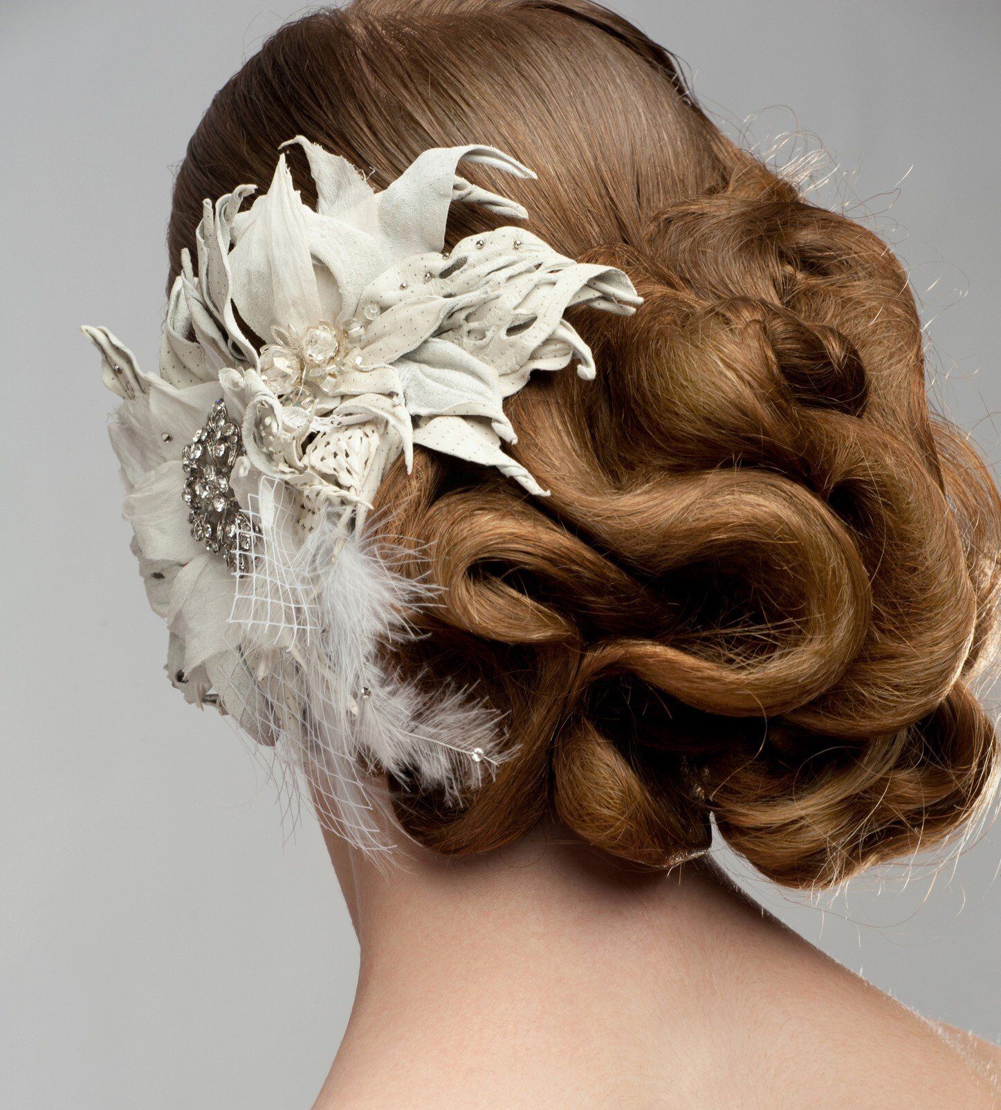 Beautiful up-do seen from behind with feathered and flower pin