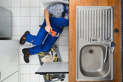 Plumber Working On Kitchen Sink