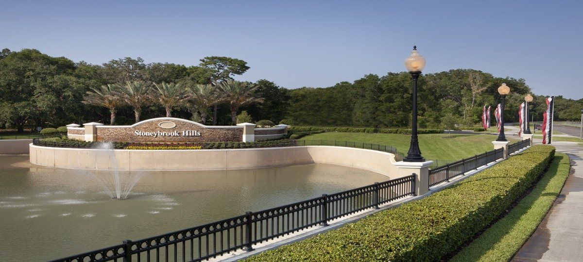 A fenced in area with a pond and a sign that says 