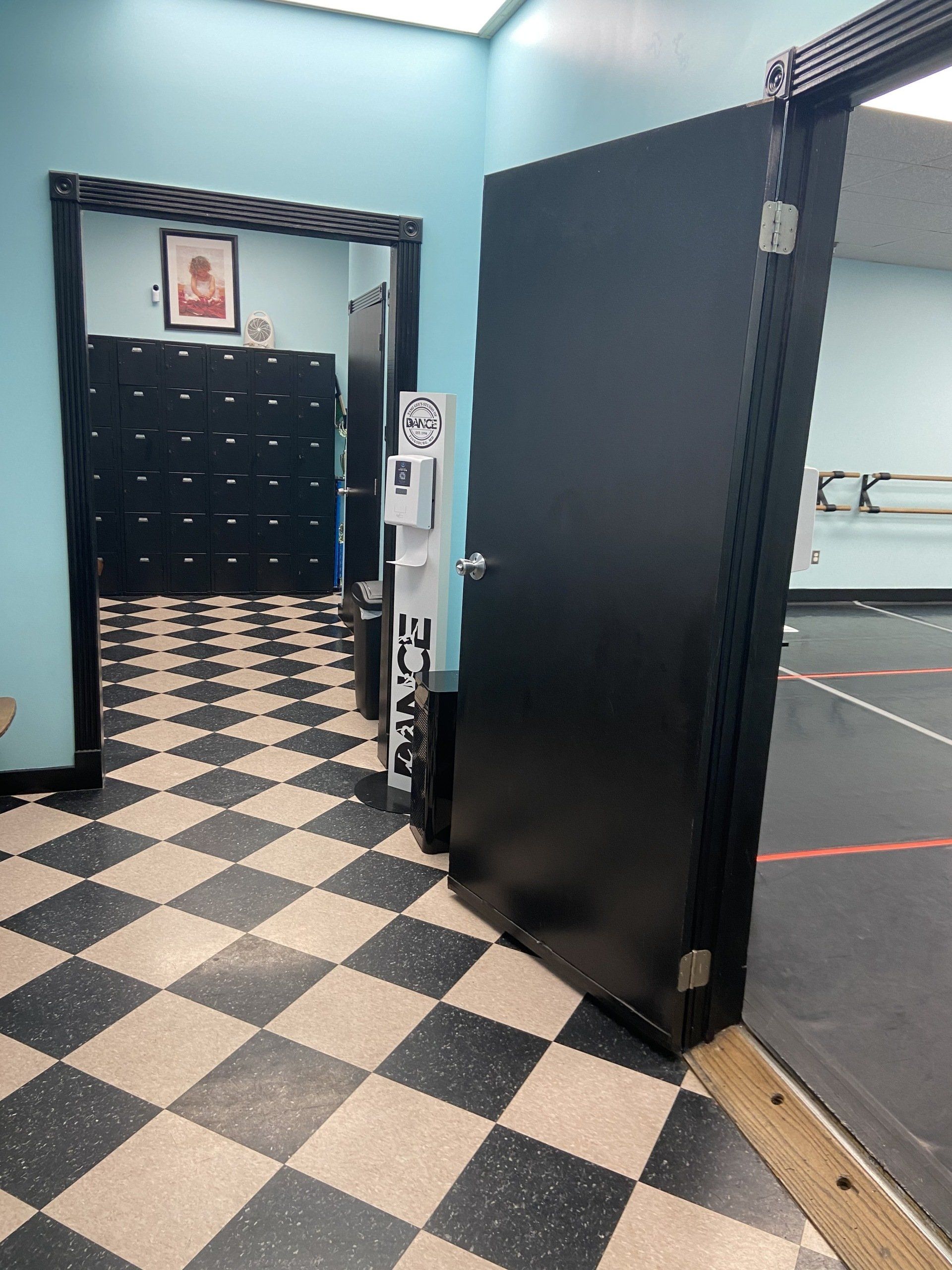 A room with a checkered floor and a black door