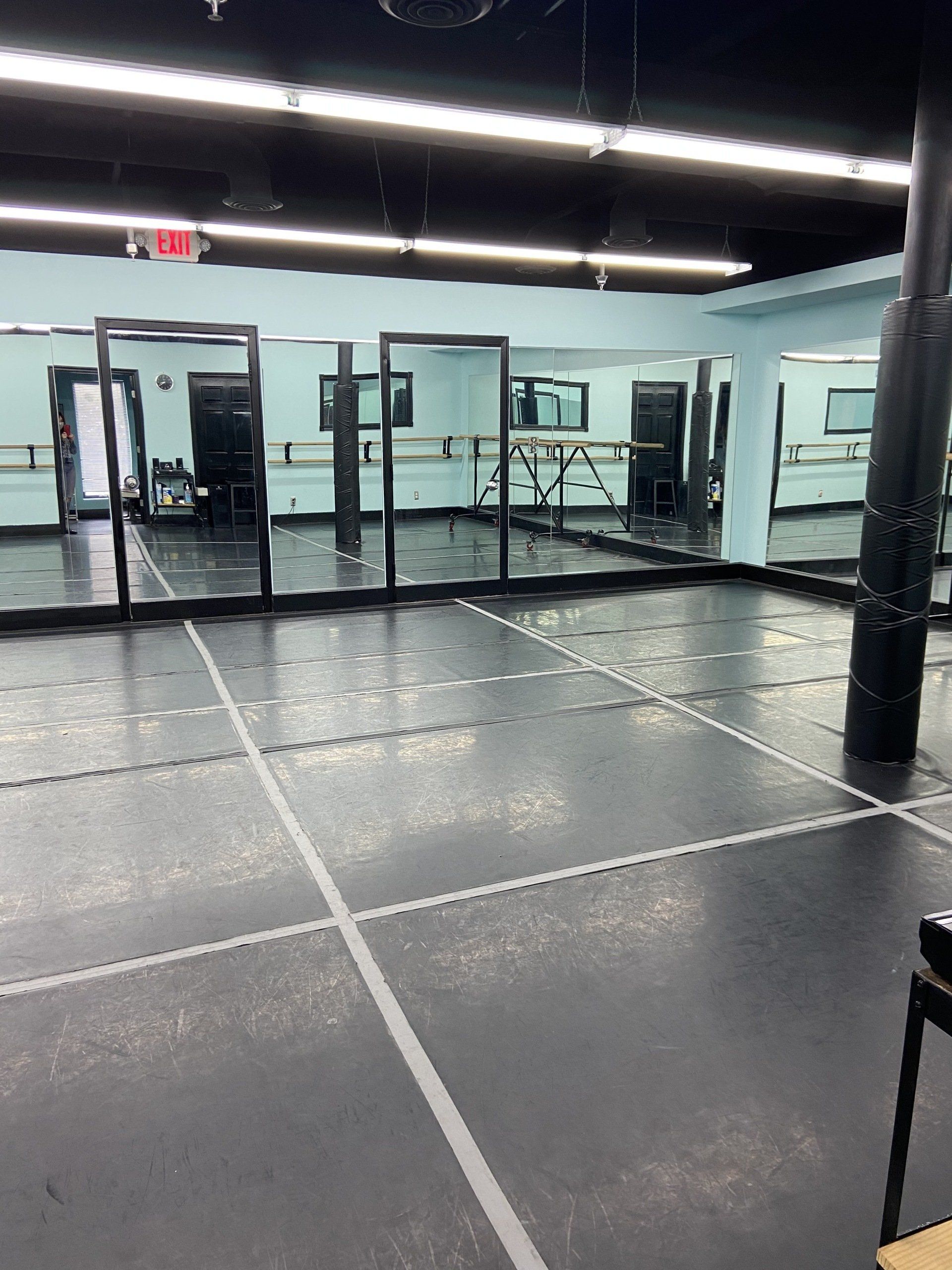 A large empty dance studio with a lot of mirrors.