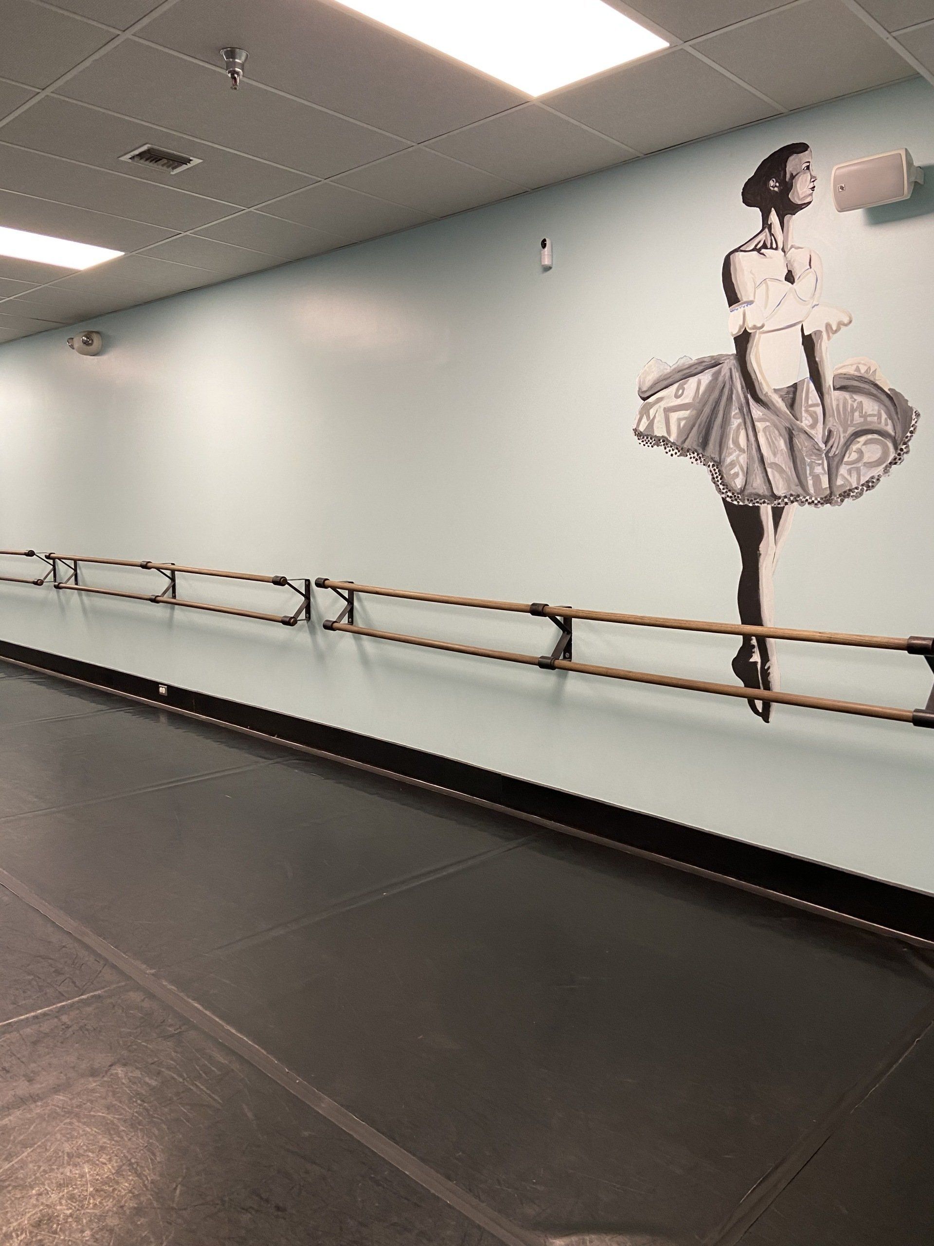 A dance studio with a picture of a ballerina on the wall