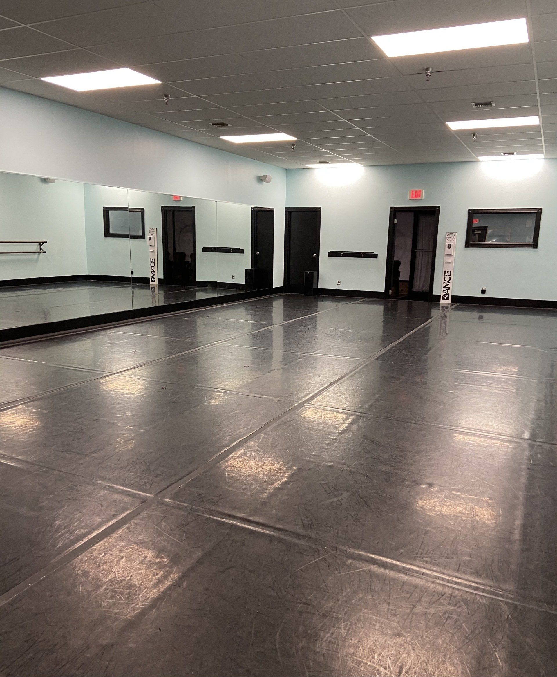 An empty dance studio with a large mirror on the wall