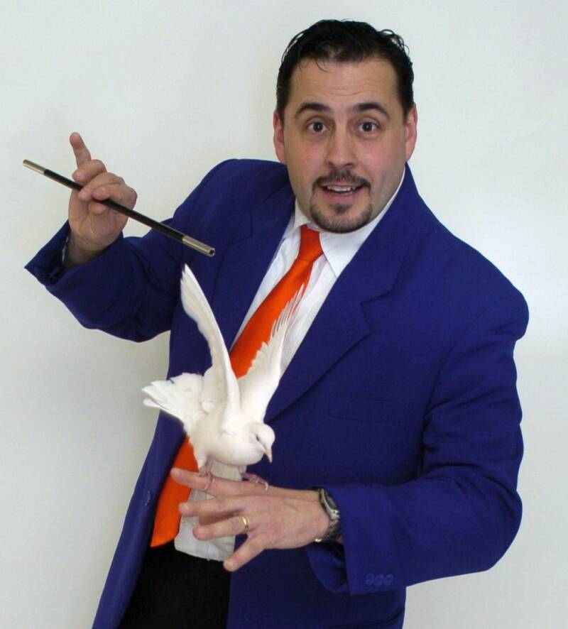 Mr. Magic with a dove that stars in his magic show assemblies.