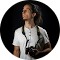 Un uomo con una camicia bianca tiene in mano una macchina fotografica.